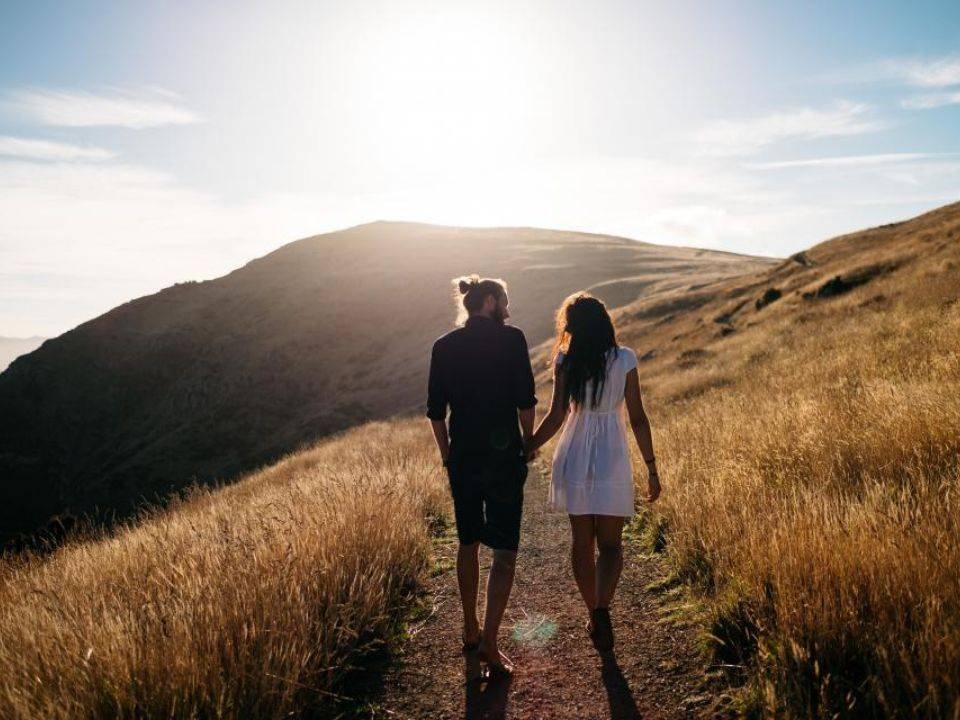 Couple walking on a hillside at sunset